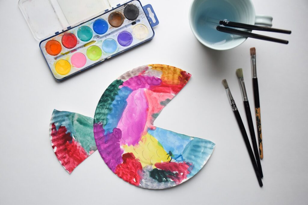 Overhead shot of child’s bright and colorful arts and crafts watercolor fish project